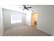 Spacious bedroom features neutral carpet, a window with blinds, and an ensuite bathroom at 7056 W Caron Dr, Peoria, AZ 85345