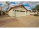 View of a two car garage with a driveway and desert landscaping at 7056 W Caron Dr, Peoria, AZ 85345