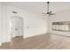 Spacious living room features light wood floors, a ceiling fan, and large window at 7056 W Caron Dr, Peoria, AZ 85345