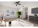 Bright bedroom with a ceiling fan, large window, and ensuite bathroom at 7056 W Caron Dr, Peoria, AZ 85345