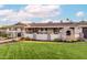 Charming home with stone-accented walls, an outdoor fireplace, and a lush green lawn at 7417 E Bonita Dr, Scottsdale, AZ 85250