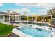 Backyard hot tub with pool, umbrellas, and lush landscaping creating a serene outdoor retreat at 7417 E Bonita Dr, Scottsdale, AZ 85250