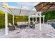 Outdoor seating area with pergola, comfortable furniture, and travertine pavers, perfect for entertaining at 7417 E Bonita Dr, Scottsdale, AZ 85250