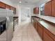 Modern kitchen featuring stainless steel appliances, wood cabinets, and tile flooring at 7720 W Pipestone Pl, Phoenix, AZ 85035