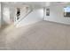 Spacious living room featuring staircase, neutral carpet and lots of natural light at 7720 W Pipestone Pl, Phoenix, AZ 85035