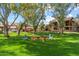 Outdoor common area featuring a fire pit and colorful Adirondack chairs amid lush trees at 8700 E Mountain View Rd # 2058, Scottsdale, AZ 85258