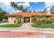Community clubhouse featuring a red tile roof, mature landscaping, and a welcoming entrance at 8700 E Mountain View Rd # 2058, Scottsdale, AZ 85258