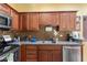 Cozy kitchen featuring stainless steel appliances, wooden cabinets, and granite countertops at 8700 E Mountain View Rd # 2058, Scottsdale, AZ 85258