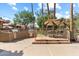 Outdoor kitchen and dining area featuring stainless steel appliances, umbrella-shaded table, and mature landscaping for community enjoyment at 8700 E Mountain View Rd # 2058, Scottsdale, AZ 85258