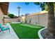 Private backyard with putting green, desert landscaping, turf, trees, and paver patio at 9088 E Winchcomb Dr, Scottsdale, AZ 85260