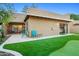 Backyard boasts a putting green, desert landscaping, trees, turf, covered patio, and paver patio at 9088 E Winchcomb Dr, Scottsdale, AZ 85260
