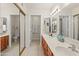 Bathroom featuring double sinks, vanity, a mirrored closet and an additional door for privacy at 9088 E Winchcomb Dr, Scottsdale, AZ 85260