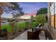 Inviting front porch with wicker seating, plants, and a tranquil view of the front yard and street at 9088 E Winchcomb Dr, Scottsdale, AZ 85260
