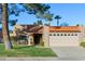 Charming home featuring a red tile roof, two-car garage, and a well-maintained front lawn with mature landscaping at 9088 E Winchcomb Dr, Scottsdale, AZ 85260