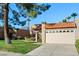 Attractive single-story home boasts a red tile roof, front lawn with mature trees, and a two-car garage at 9088 E Winchcomb Dr, Scottsdale, AZ 85260