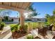 Cozy outdoor patio with stylish wicker chairs, a patterned tile floor, and views of the front yard at 9088 E Winchcomb Dr, Scottsdale, AZ 85260