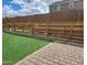 The backyard features artificial turf, a paver patio, and a partially constructed wooden fence at 9207 W Sells Dr, Phoenix, AZ 85037