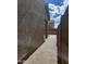 Narrow walkway between the house and a block wall, offering privacy and access at 9207 W Sells Dr, Phoenix, AZ 85037