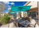 Back patio with dining table, barbecue, and ample seating beneath a turquoise umbrella, ideal for outdoor gatherings at 9475 N 115Th Pl, Scottsdale, AZ 85259