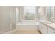 Bright bathroom with a glass block window, soaking tub and glass enclosed shower at 9475 N 115Th Pl, Scottsdale, AZ 85259