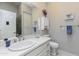 Bathroom features white cabinetry, a large mirror, a sink, a toilet, and decorative accents at 9475 N 115Th Pl, Scottsdale, AZ 85259