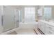 Bright bathroom featuring a soaking tub with glass block window and a separate glass enclosed shower at 9475 N 115Th Pl, Scottsdale, AZ 85259