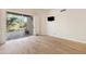Bedroom with wood floors leading to an outdoor patio and natural light at 9475 N 115Th Pl, Scottsdale, AZ 85259