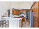 Bright kitchen with stainless steel appliances, an island with seating, and light wood floors at 9475 N 115Th Pl, Scottsdale, AZ 85259
