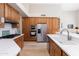 Bright kitchen boasts stainless steel appliances, wooden cabinets and a spacious island with white countertops at 9475 N 115Th Pl, Scottsdale, AZ 85259