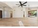 Bright living room featuring light wood floors, ceiling fans and sliding glass doors to the outside at 9475 N 115Th Pl, Scottsdale, AZ 85259