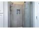 Modern shower with gray stone tile, a built-in niche, and a frameless glass door at 9475 N 115Th Pl, Scottsdale, AZ 85259