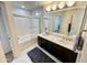 Bright bathroom highlighting a double sink vanity, shower-tub combo, and white tile flooring at 10249 N 12Th Pl # 2, Phoenix, AZ 85020