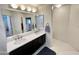 Bathroom featuring a double sink vanity with modern fixtures, a neutral color palette, and ample lighting at 10249 N 12Th Pl # 2, Phoenix, AZ 85020