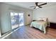 Sunny bedroom featuring wood-look floors and sliding glass doors to a balcony at 10249 N 12Th Pl # 2, Phoenix, AZ 85020