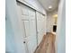 Hallway showcasing white closet doors, and wood-look flooring leading to the bathroom at 10249 N 12Th Pl # 2, Phoenix, AZ 85020