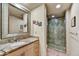 Bathroom featuring a granite countertop vanity, decorative mirror, and tiled shower at 10567 E Fernwood Ln, Scottsdale, AZ 85262