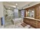 Bathroom featuring a large shower, tub and vanity with wood cabinets and granite counters at 10567 E Fernwood Ln, Scottsdale, AZ 85262