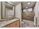 Elegant bathroom featuring granite countertops, a framed mirror, and a shower-over-tub combo at 10567 E Fernwood Ln, Scottsdale, AZ 85262