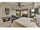 Cozy bedroom with a fireplace, ceiling fan, and balcony overlooking the golf course at 10567 E Fernwood Ln, Scottsdale, AZ 85262