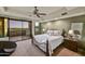 Bedroom with ceiling fan and sliding glass doors to a private patio overlooking the golf course at 10567 E Fernwood Ln, Scottsdale, AZ 85262