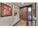 Elegant foyer features a custom wood door, intricate tile flooring, and artful decor leading to an office at 10567 E Fernwood Ln, Scottsdale, AZ 85262