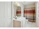 Bright bathroom with a large mirror, striped shower curtain, and white tile flooring at 11216 E Appaloosa Pl, Scottsdale, AZ 85259