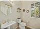 Elegant powder room with pedestal sink, unique mirror, and decorative glass block window for natural light at 11216 E Appaloosa Pl, Scottsdale, AZ 85259