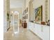 Long hallway featuring a display of artwork, decorative lighting, and a white built in cabinet at 11216 E Appaloosa Pl, Scottsdale, AZ 85259