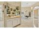 Hallway wet bar featuring mirrored shelving, artwork, and white cabinets at 11216 E Appaloosa Pl, Scottsdale, AZ 85259