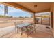 A covered back patio with a dining table looks out onto a spacious backyard at 14450 N 132Nd Dr, Surprise, AZ 85379