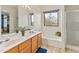 Bright bathroom featuring a double vanity, soaking tub, and separate shower, filled with natural light from the window at 14450 N 132Nd Dr, Surprise, AZ 85379