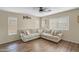 Bright and airy living room featuring a large sectional sofa, natural light, and stylish décor at 16157 W Moreland St, Goodyear, AZ 85338