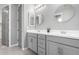 Stylish bathroom with double sinks, gray cabinetry, modern lighting, and sleek mirrors at 17810 W Straight Arrow Ln, Surprise, AZ 85387