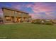 Stunning twilight view of the backyard featuring a covered patio, lawn, pool, and outdoor seating areas at 18187 E Via Jardin --, Gold Canyon, AZ 85118